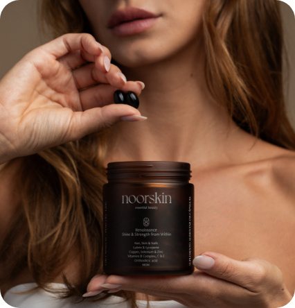 Mulher segurando as cápsulas do nutricosmético para cabelos e unhas da noorskin, que está com 30% off na black friday