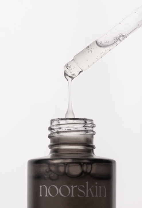 mulher tomando banho e segurando o gel de banho da noorskin