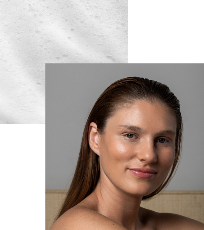 Retrato de uma mulher com pele radiante, sorriso suave, em ambiente de interior com fundo neutro, acompanhada de uma espuma Ella biome