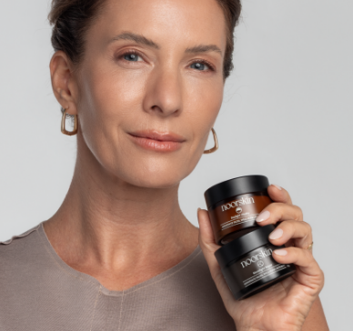 Mulher segurando copo térmico I AM ESSENTIAL preto brinde exclusivo semana do médico.
