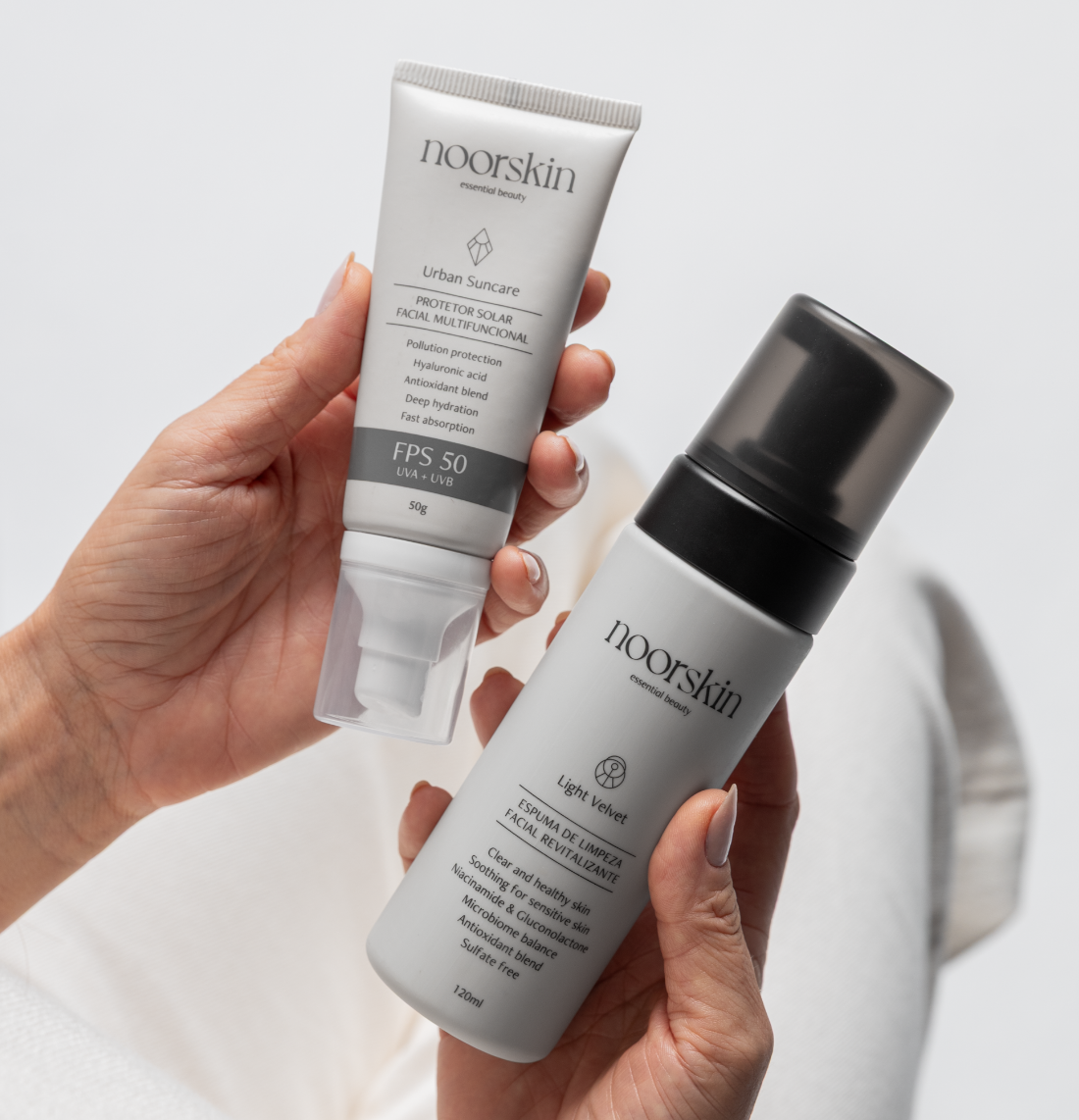 Mulher de branco segurando Hidratante facial Moonlight Repair Noorskin e um Nutraceutrico Renaissance Noorskin.