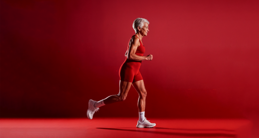 foto de uma mulher idosa correndo com roupas de academia vermelhas