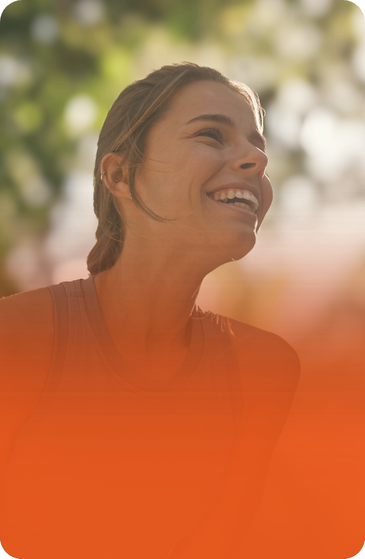 Mulher com um sorriso radiante, destacando-se em um fundo laranja.