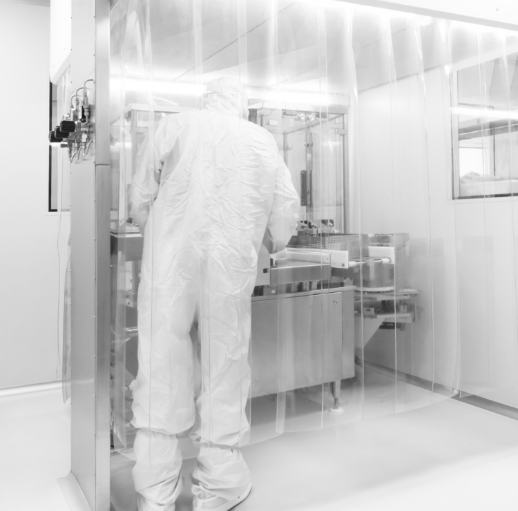 Uma pessoa de altamente protegida está posicionada em um laboratório esterilizado, focada na produção de colírios