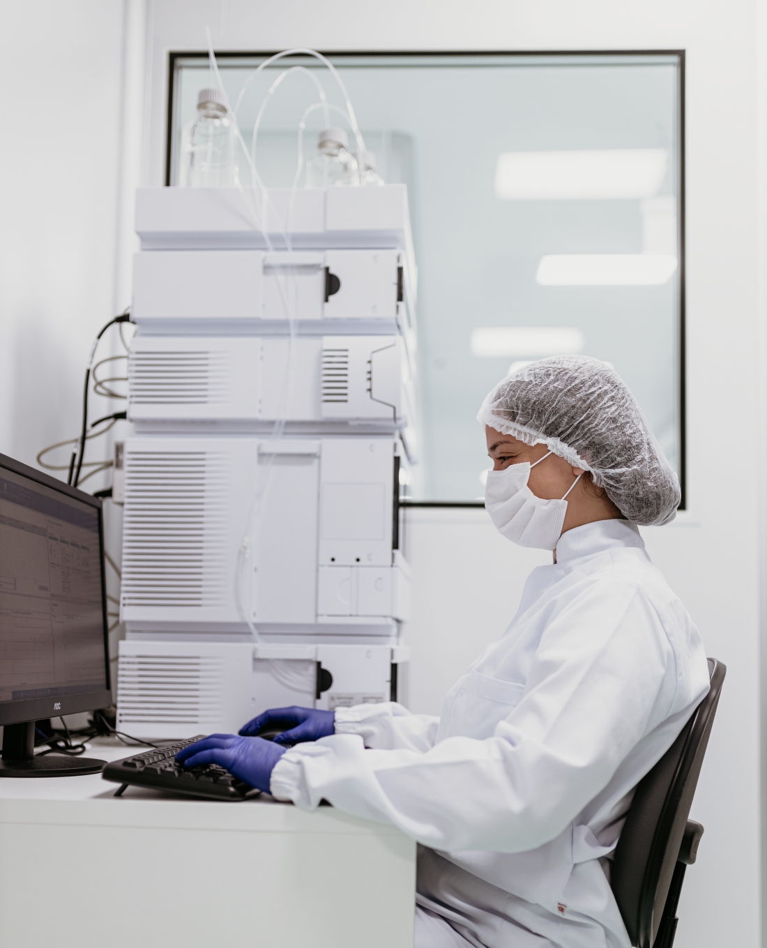 Técnico utilizando micropipeta para transferir amostra para frasco de vidro âmbar em laboratório farmacêutico