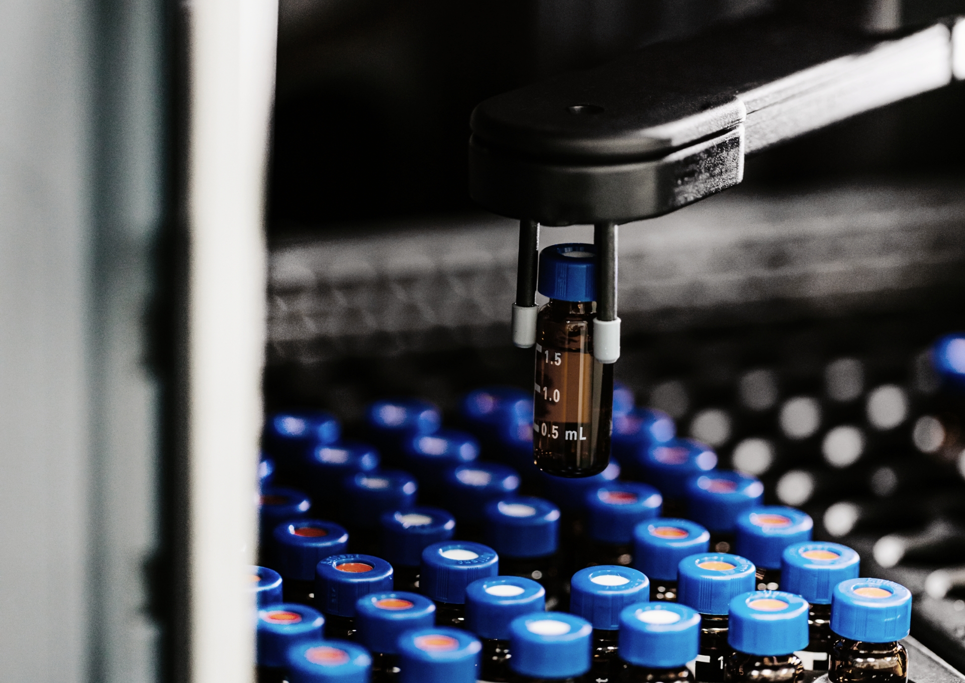 Profissional realizando inspeção de ampolas de medicamentos injetáveis em laboratório